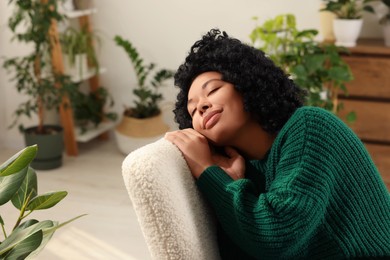 Photo of Woman relaxing surrounded by beautiful houseplants at home. Space for text