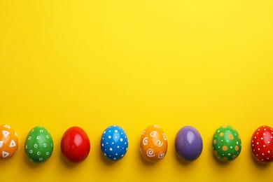 Decorated Easter eggs and space for text on color background, top view