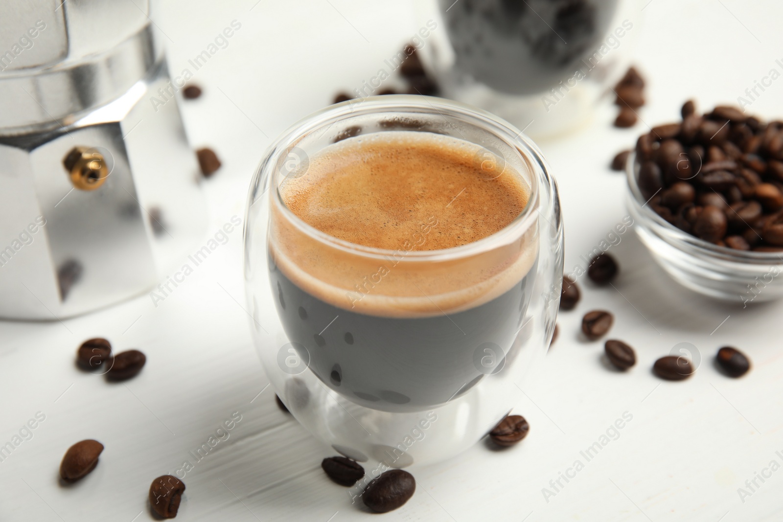 Photo of Cup of tasty coffee and beans on white wooden table