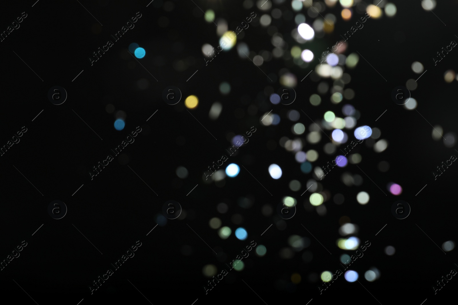 Photo of Blurred view of colorful festive lights on black background. Bokeh effect