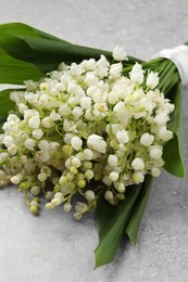 Beautiful lily of the valley bouquet on grey table, closeup