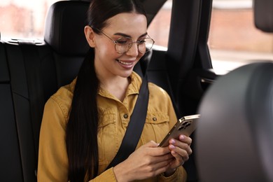 Woman with seatbelt using phone inside car