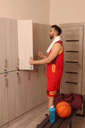 Photo of Handsome man near open locker in changing room