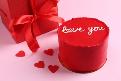 Bento cake with text Love You, gift box and paper hearts on pink table. St. Valentine's day surprise