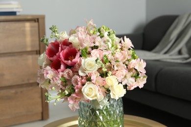 Beautiful bouquet of fresh flowers on coffee table in room