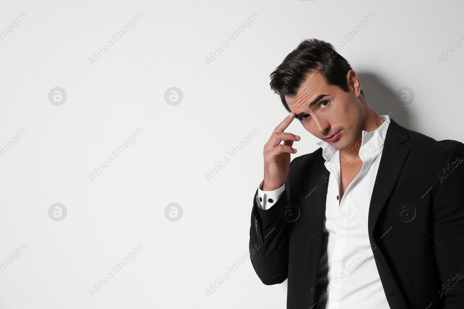Photo of Handsome young man in elegant suit on light beige background. Space for text