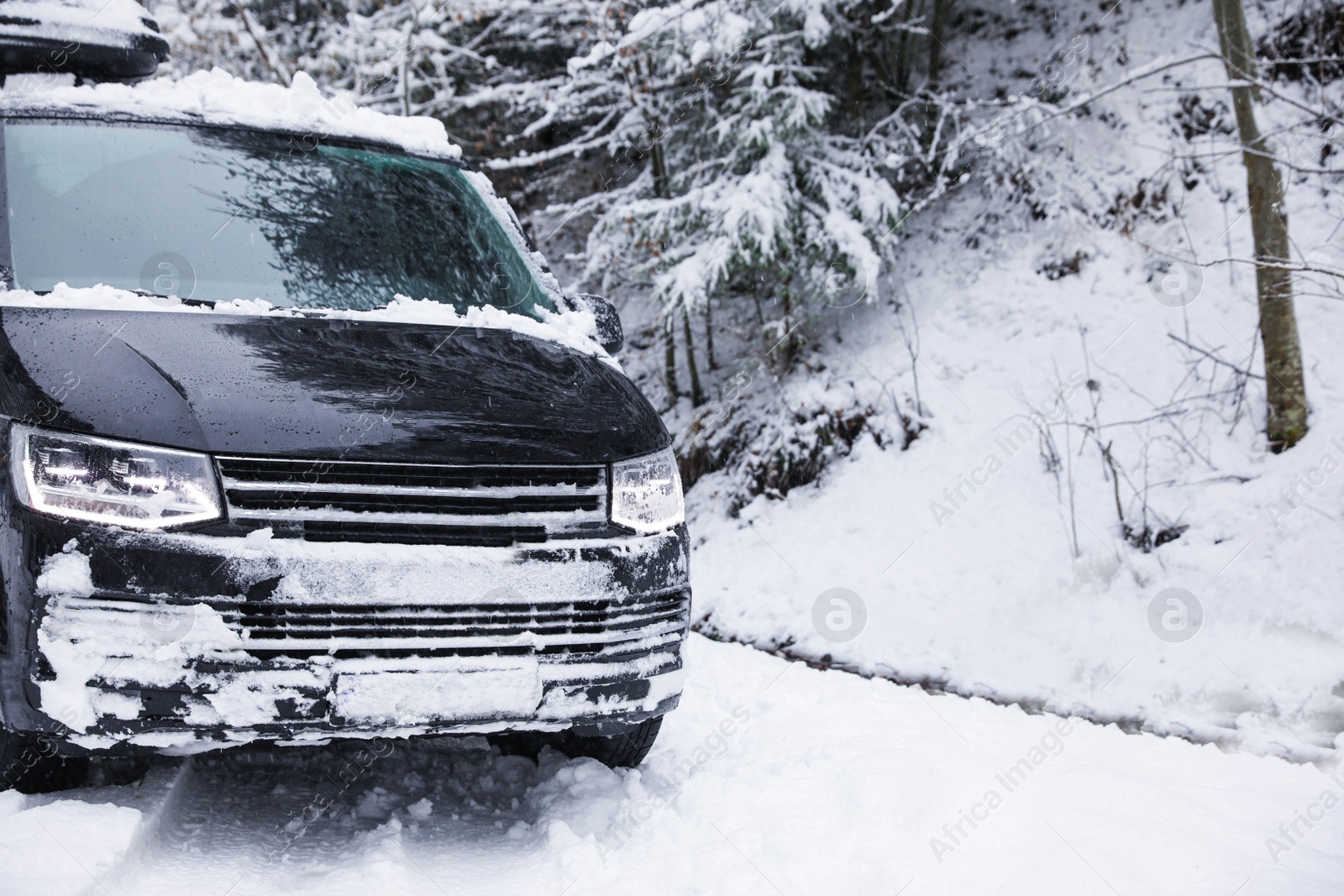 Photo of Modern car on snowy road near forest. Winter weather