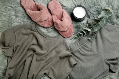 Photo of Flat lay composition with fluffy slippers and pajamas on fuzzy carpet. Comfortable home outfit