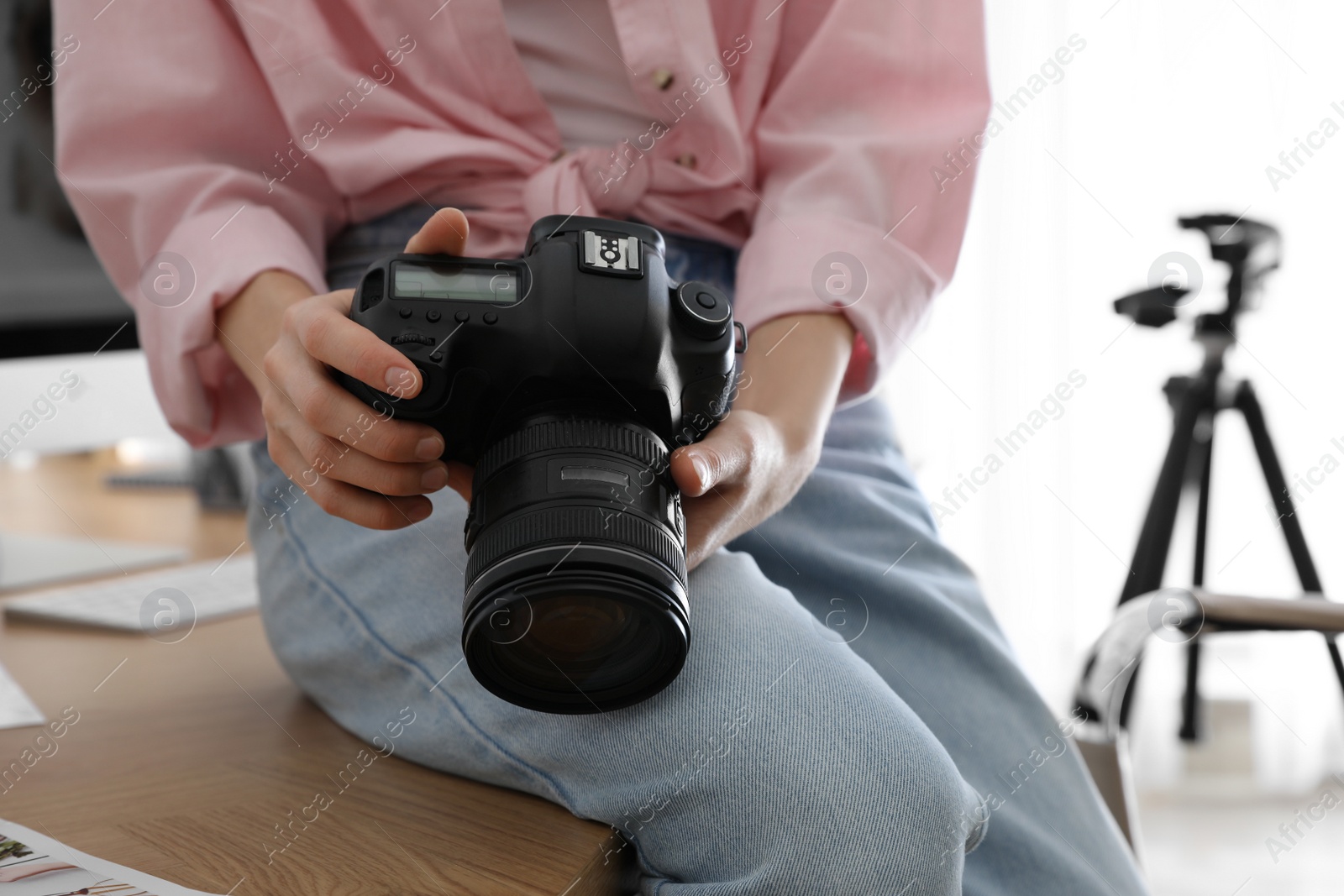 Photo of Professional photographer with camera working in office, closeup