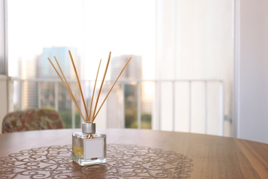 Reed air freshener on wooden table in room