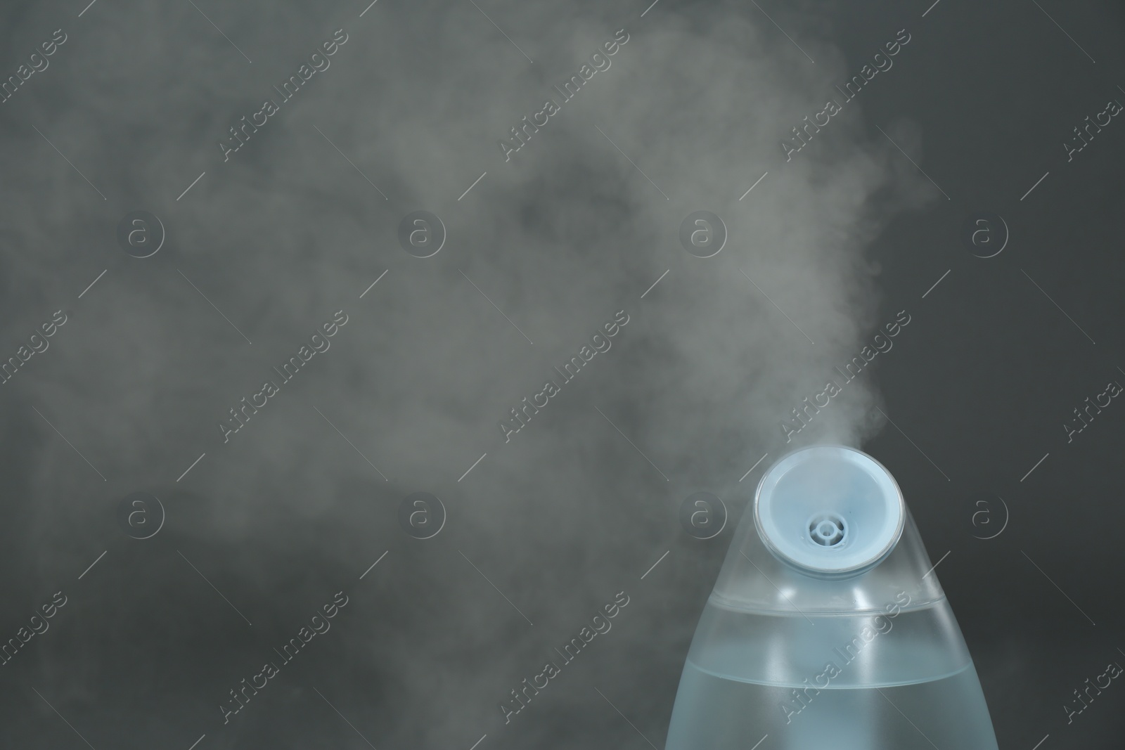 Photo of Modern air humidifier on grey background, closeup. Space for text