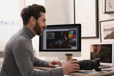 Professional photographer with digital camera at table in office