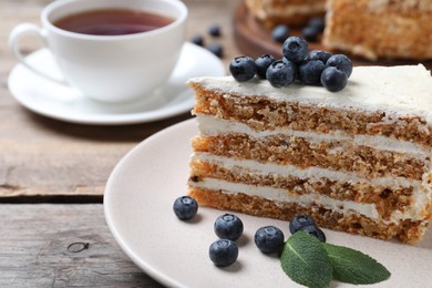 Photo of Tasty cake with berries on wooden table, closeup