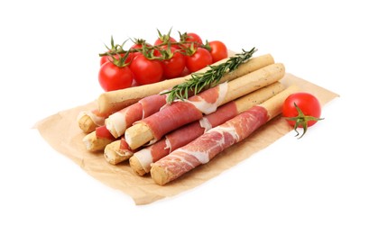 Delicious grissini sticks with prosciutto, tomatoes and rosemary on white background