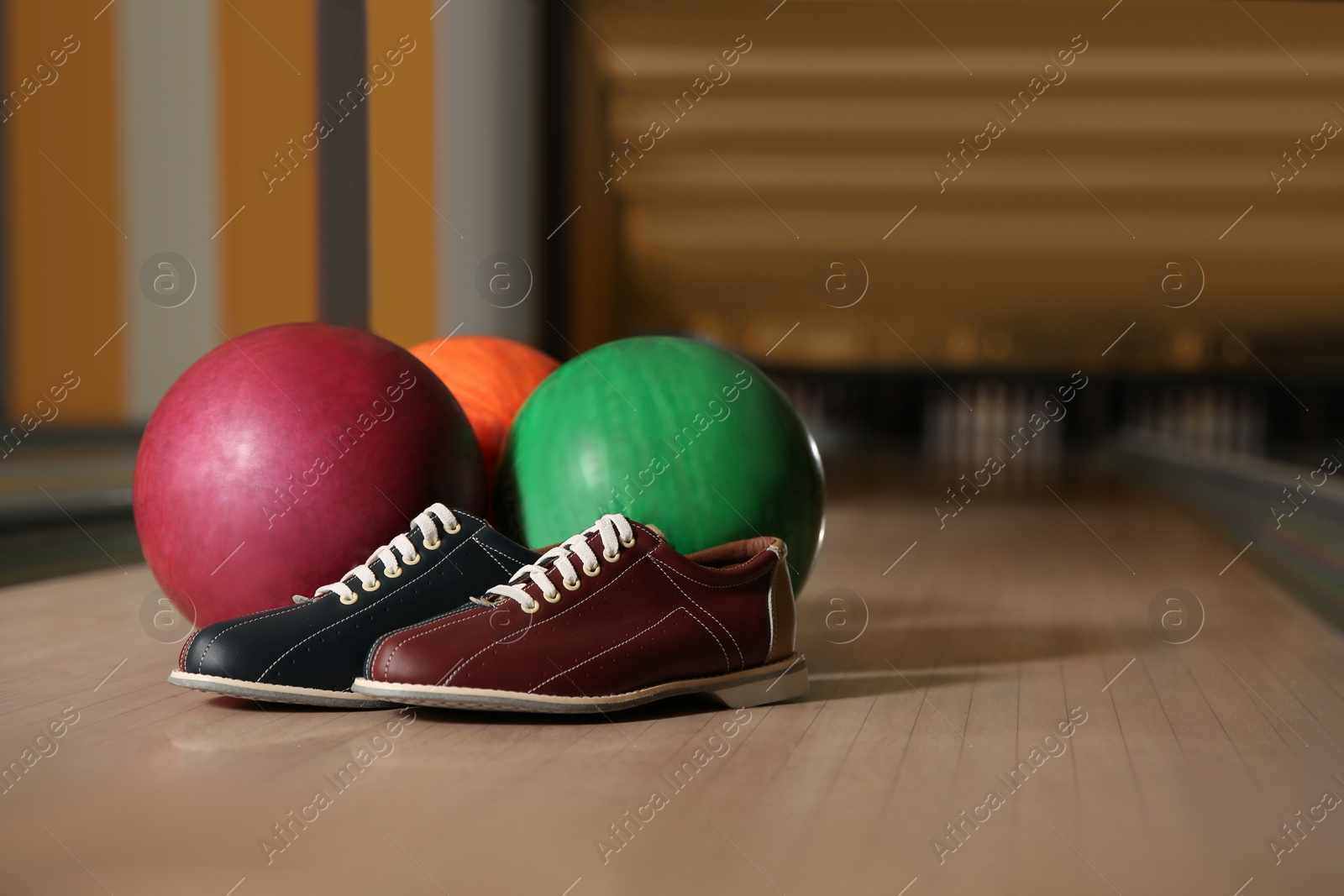 Photo of Shoes and balls on bowling lane in club. Space for text