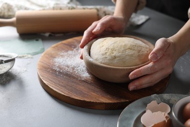 Photo of Woman making dough at grey table, closeup