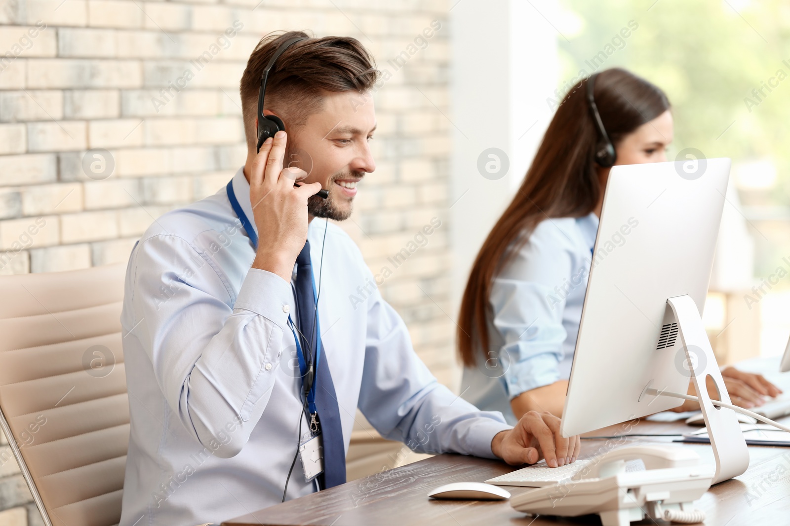 Photo of Technical support operators with headsets at workplace