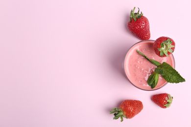 Photo of Tasty strawberry smoothie with mint in glass on pink background, flat lay. Space for text