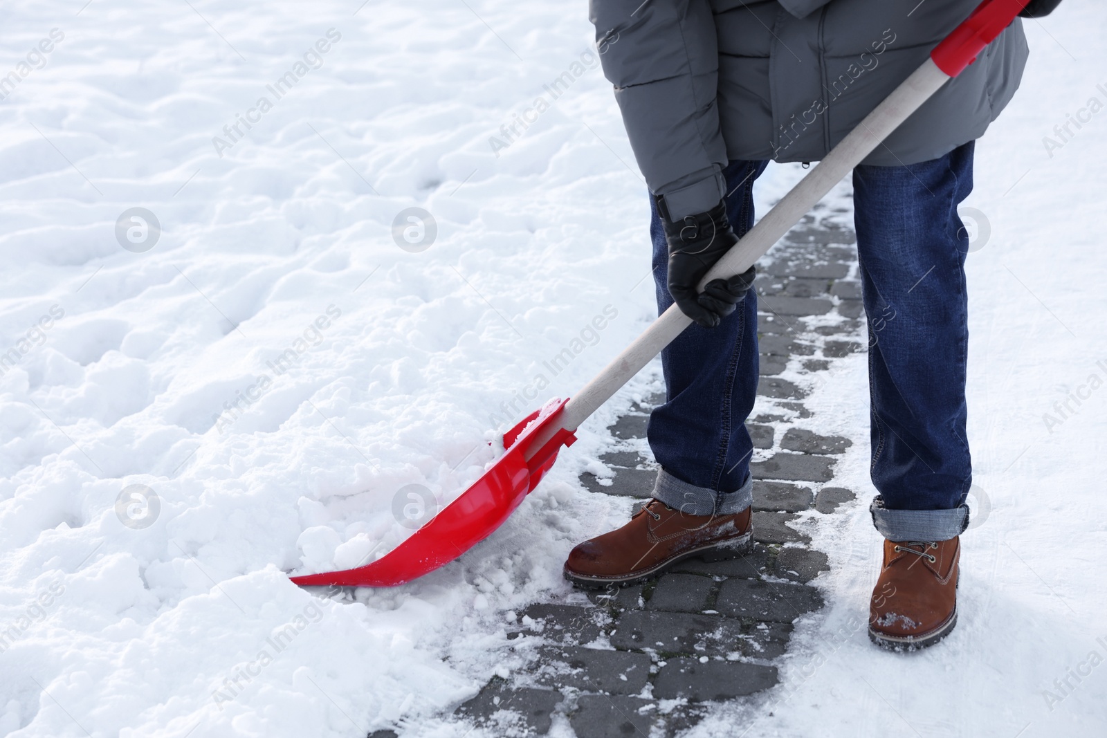 Photo of Man removing snow with shovel outdoors, closeup