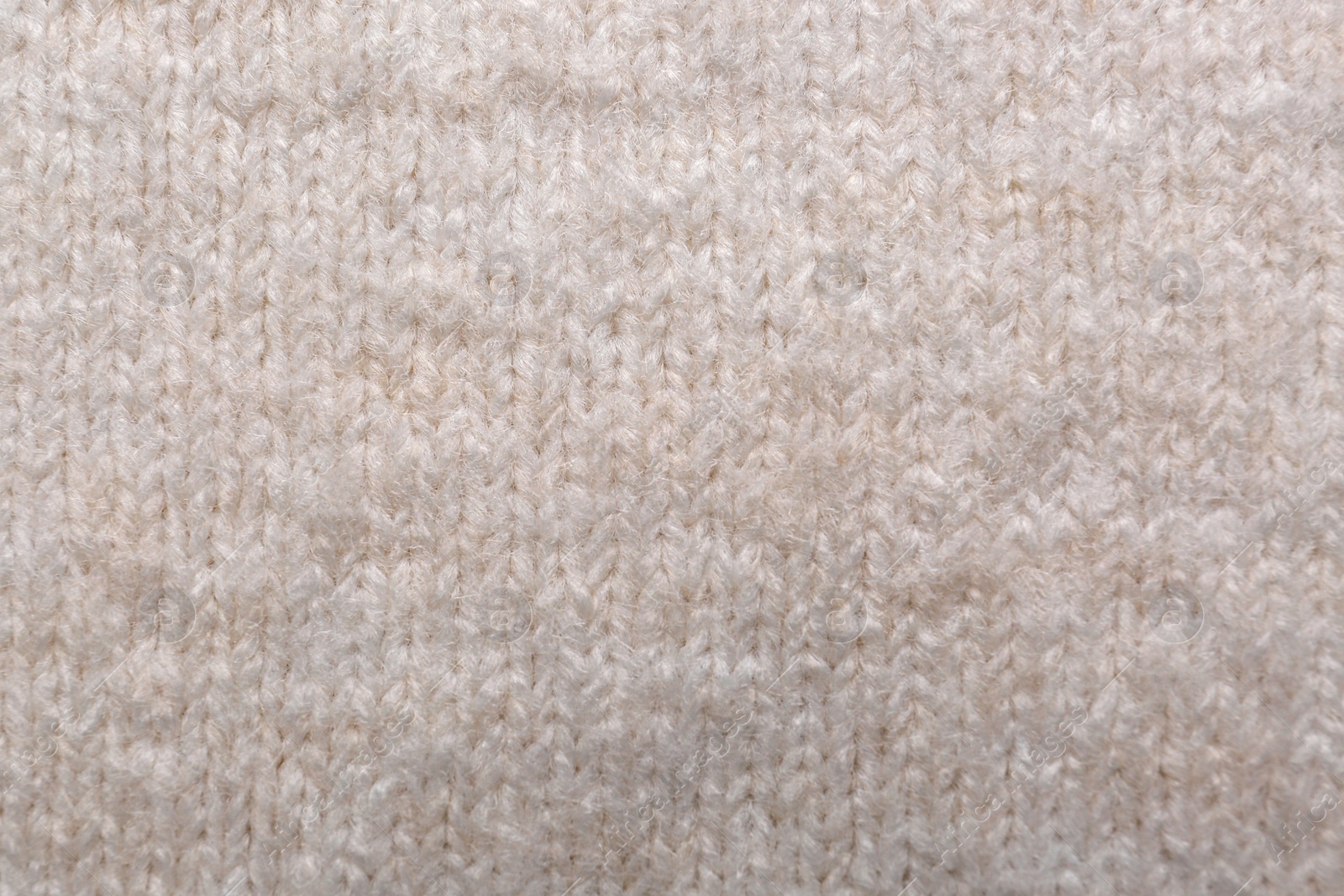 Photo of Soft beige knitted fabric as background, top view