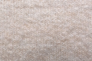 Soft beige knitted fabric as background, top view