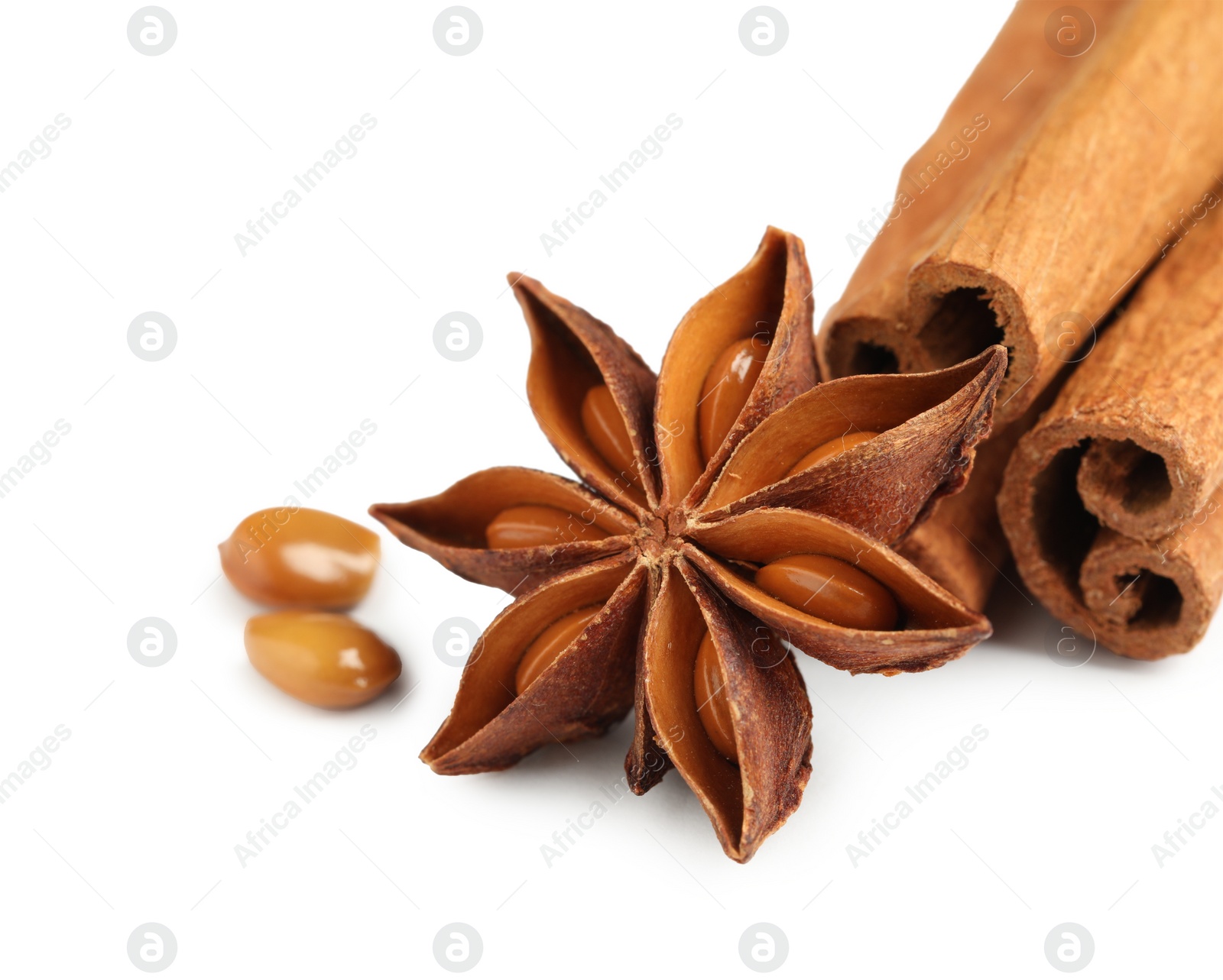 Photo of Dry anise star and cinnamon sticks on white background, closeup