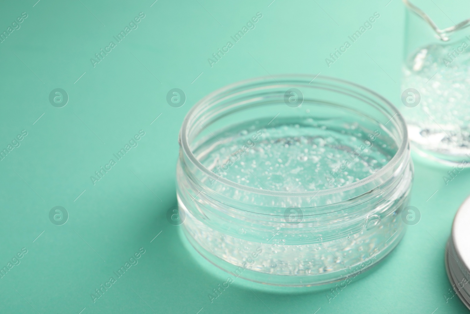 Photo of Jar of cosmetic gel on turquoise background, space for text