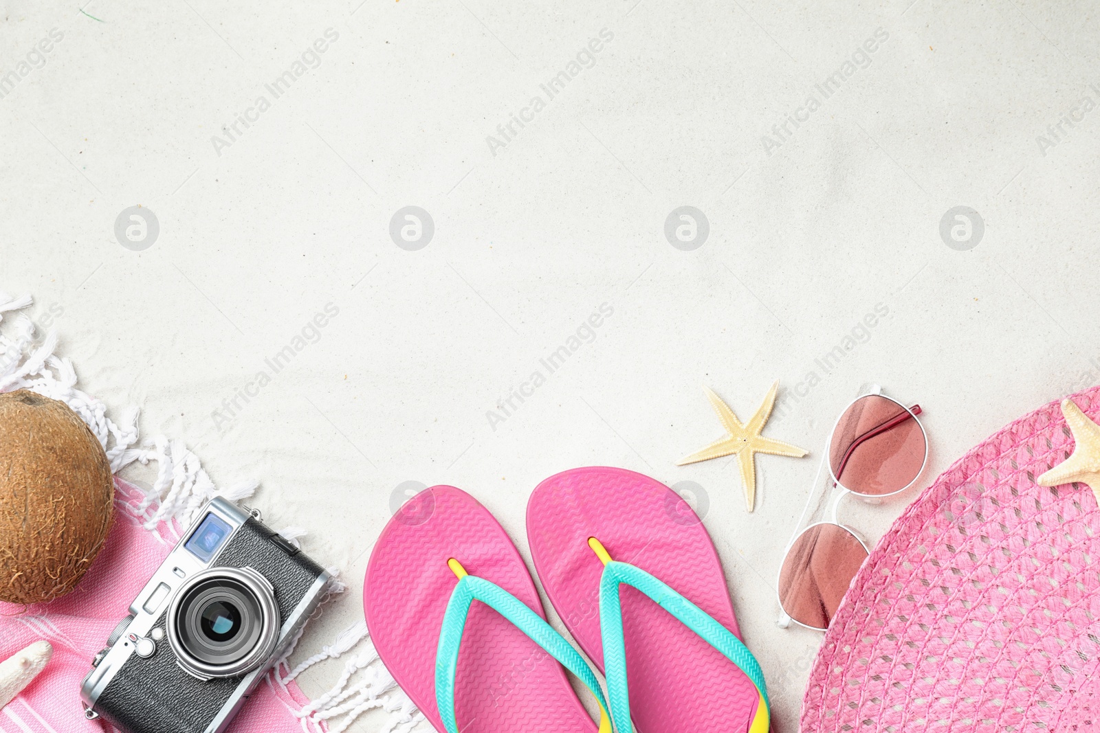 Photo of Composition with beach accessories and space for text on sand, flat lay