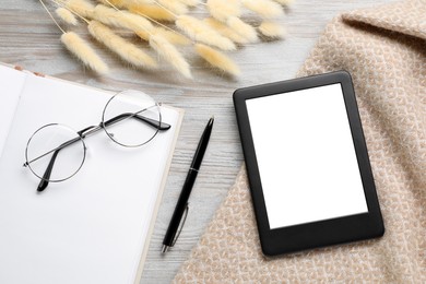 Photo of Flat lay composition with modern e-book reader on white wooden table