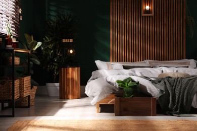 Stylish interior with large comfortable bed and potted plants