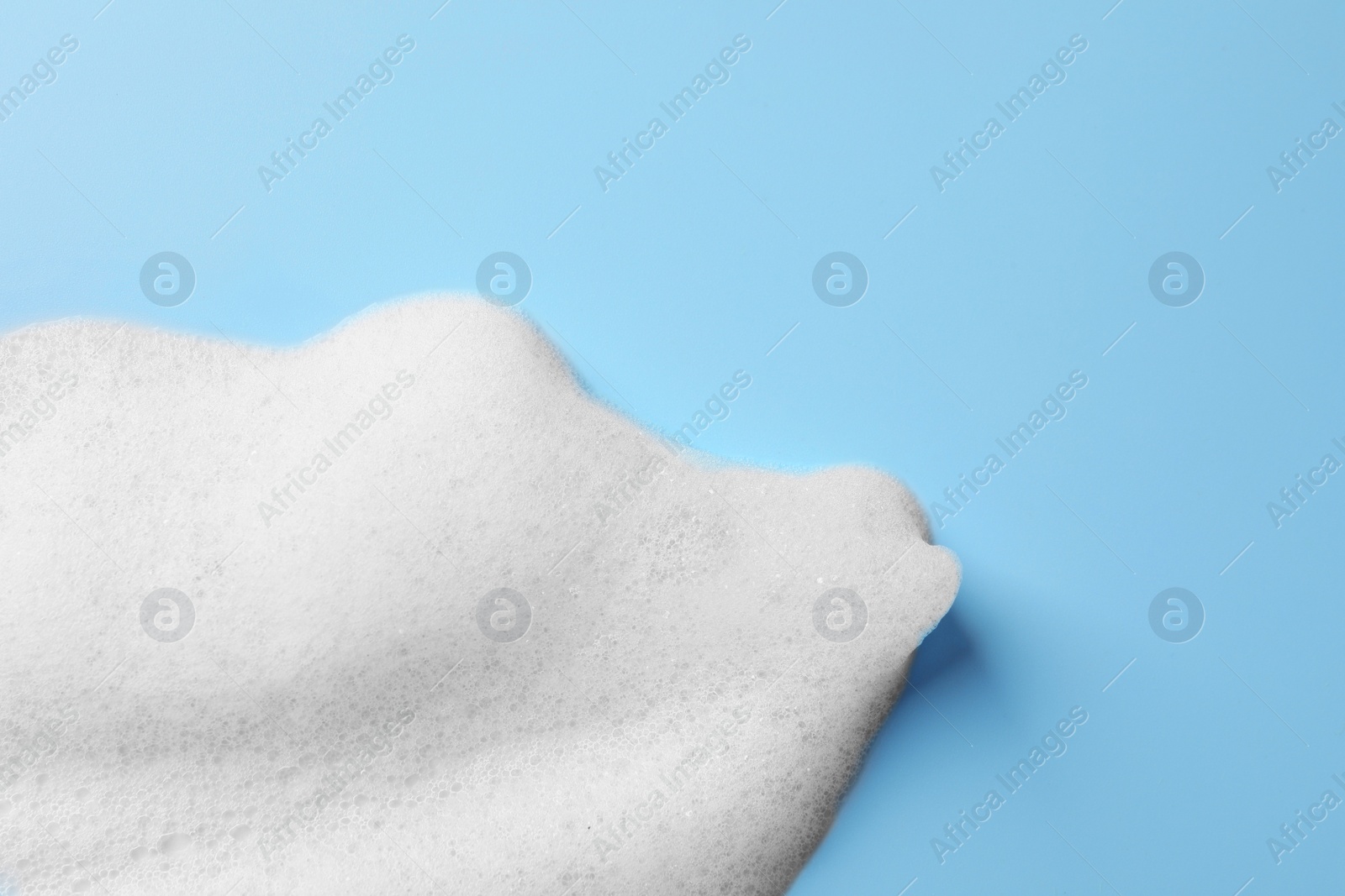 Photo of Foam sample on light blue background, top view. Space for text