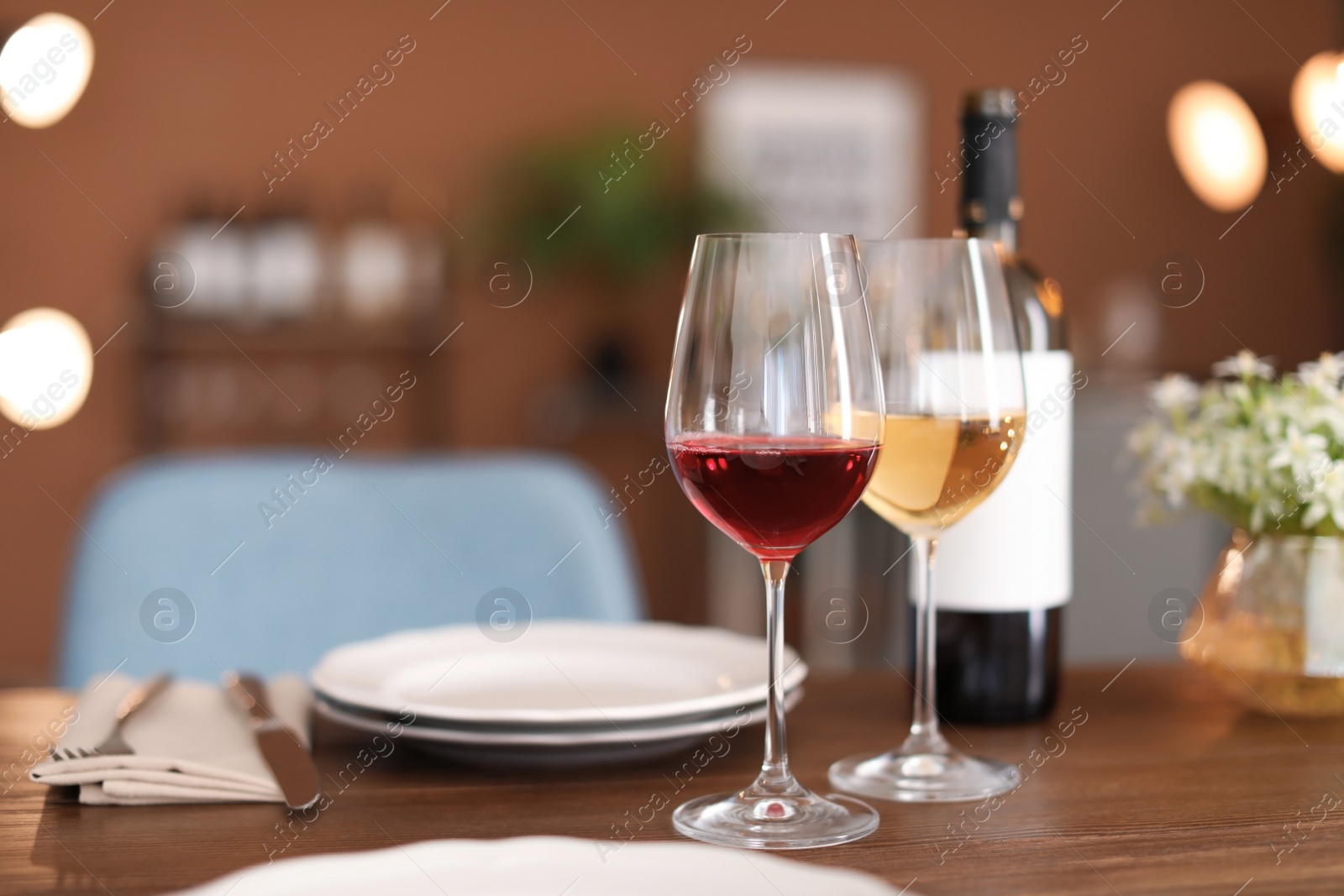 Photo of Glasses and bottle with tasty wine on table in restaurant