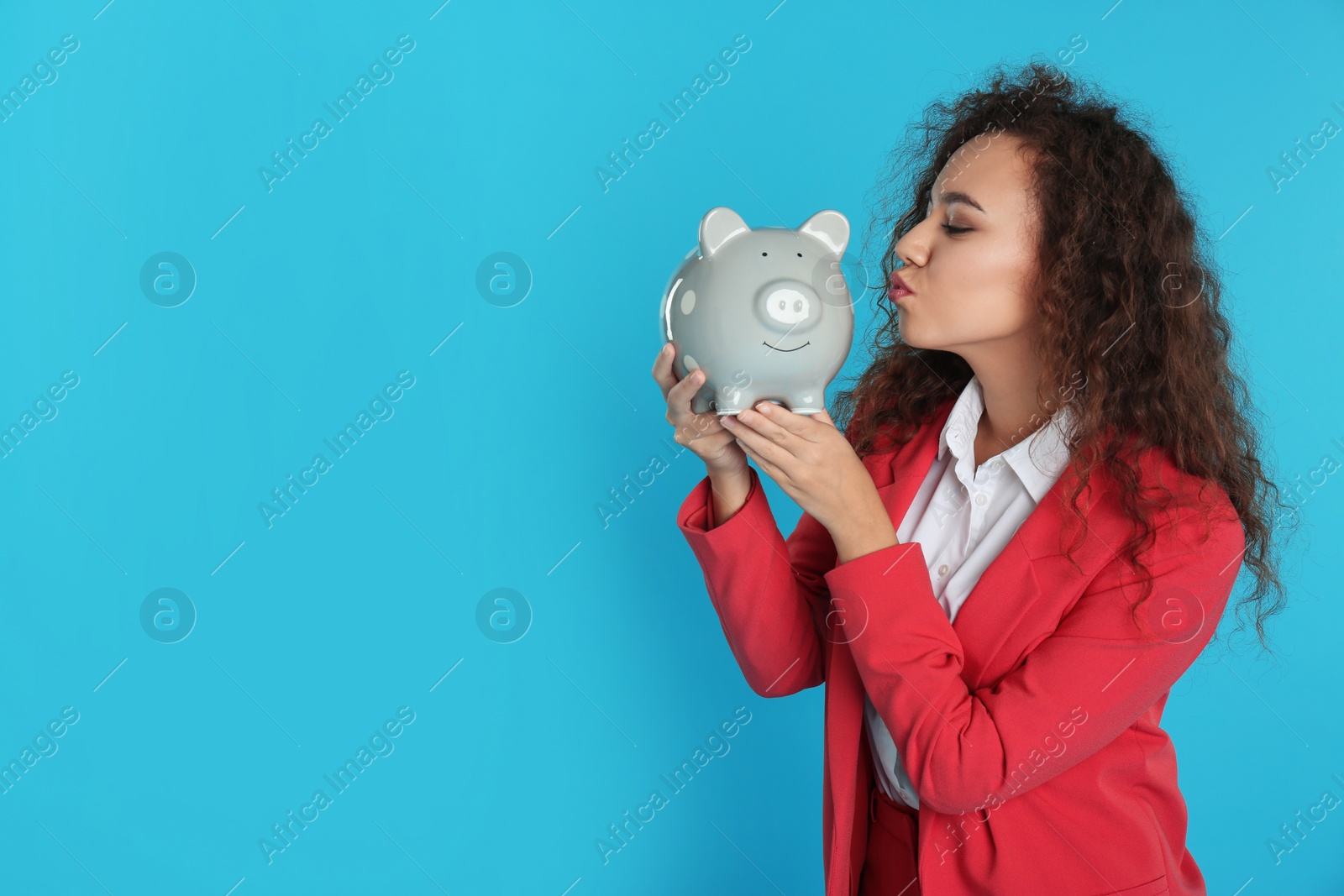 Photo of African-American businesswoman with piggy bank on color background, space for text. Money saving