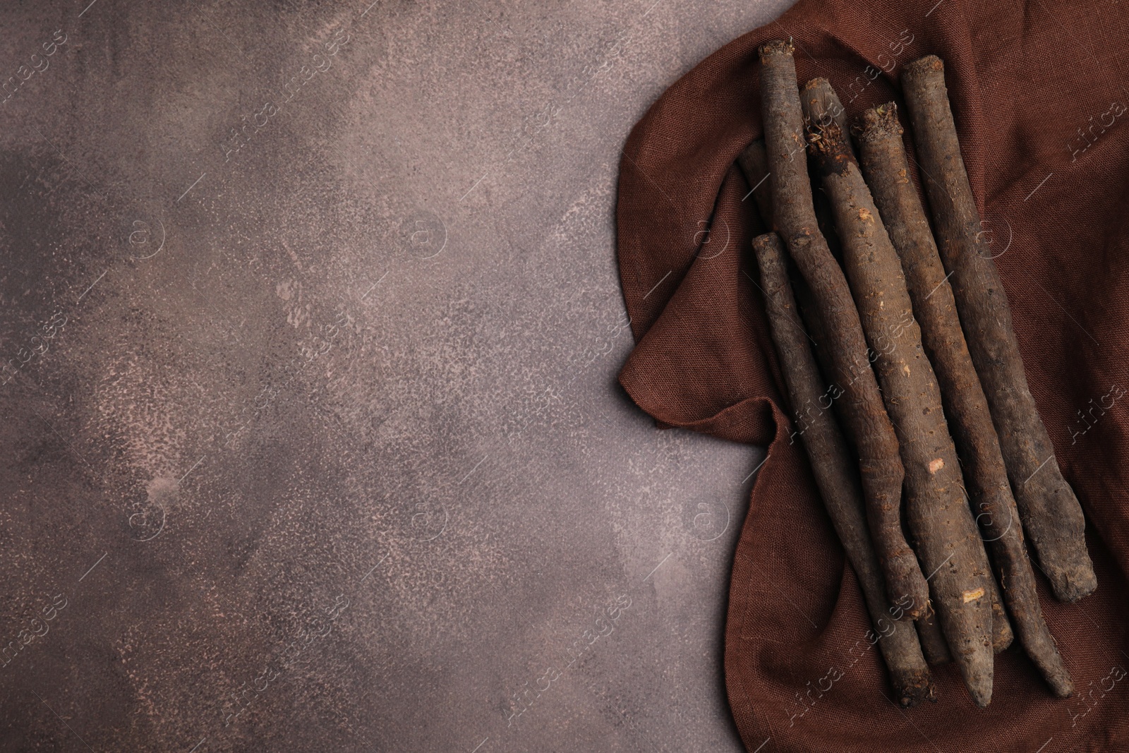 Photo of Raw salsify roots on brown table, flat lay. Space for text