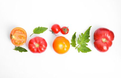 Photo of Many different ripe tomatoes and leaves on white background, flat lay