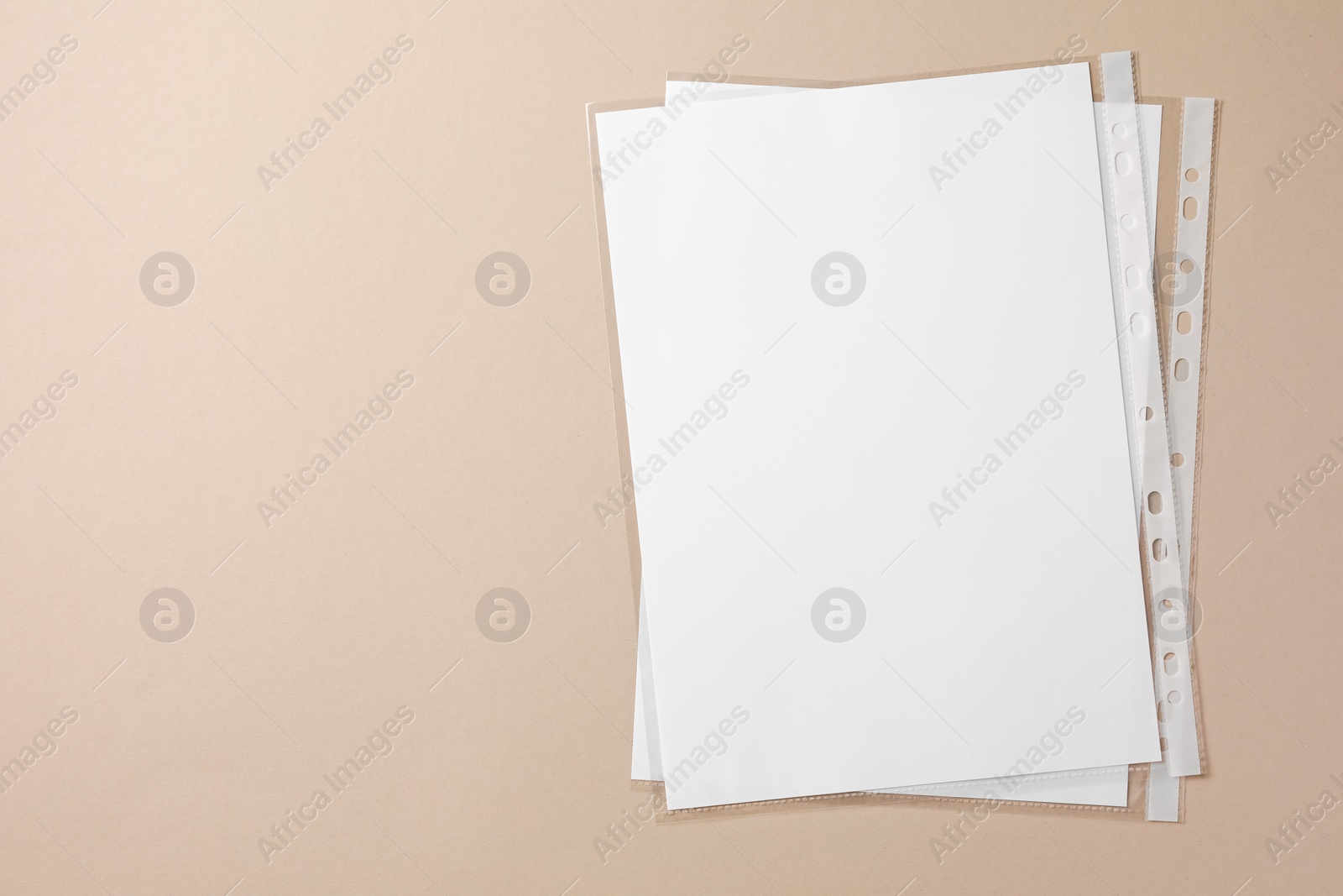 Photo of Punched pockets with paper sheets on light grey background, top view. Space for text