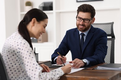 Photo of Woman signing document in lawyer's office, selective focus