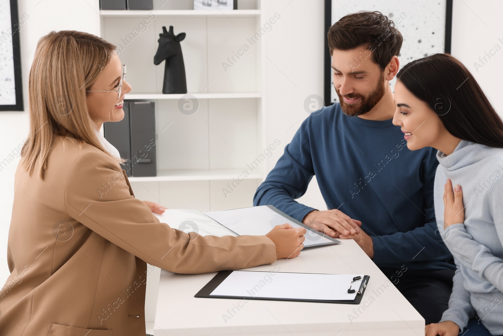 Photo of Real estate agent working with couple in office