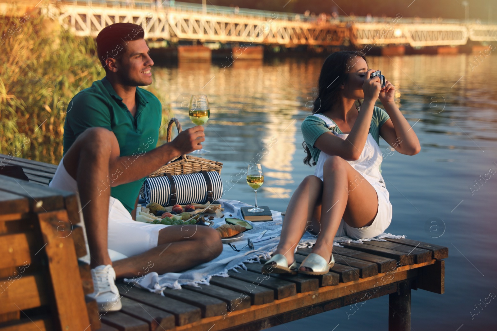 Photo of Happy couple spending time on pier at picnic