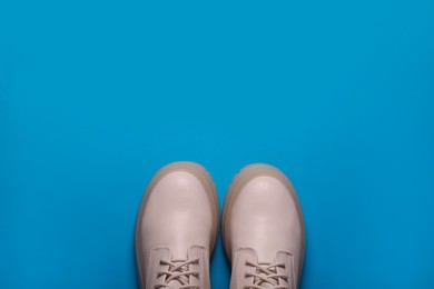 Pair of stylish leather shoes on light blue background, flat lay. Space for text