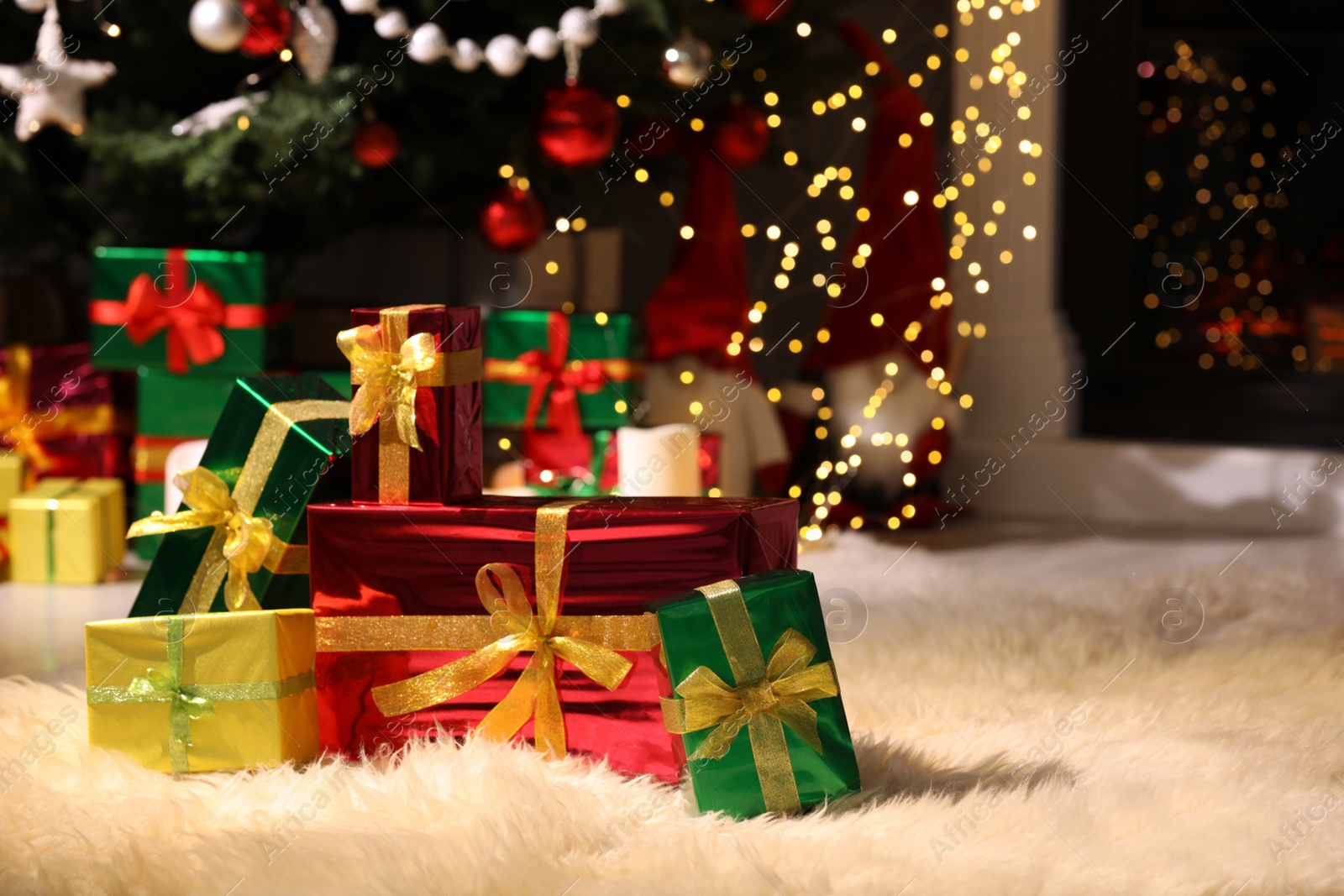 Photo of Beautiful gift boxes near Christmas tree in room, space for text