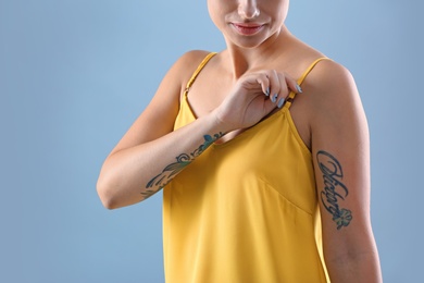 Photo of Young woman with tattoos on color background