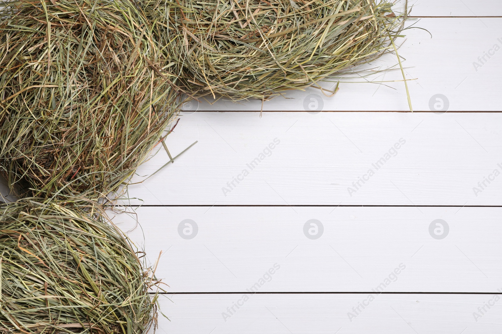 Photo of Dried hay on white wooden table, top view. Space for text