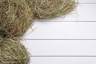 Photo of Dried hay on white wooden table, top view. Space for text