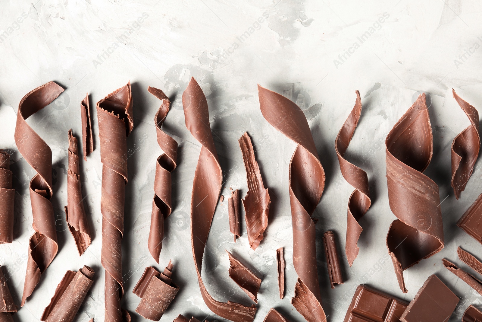 Photo of Flat lay composition with chocolate curls on light background