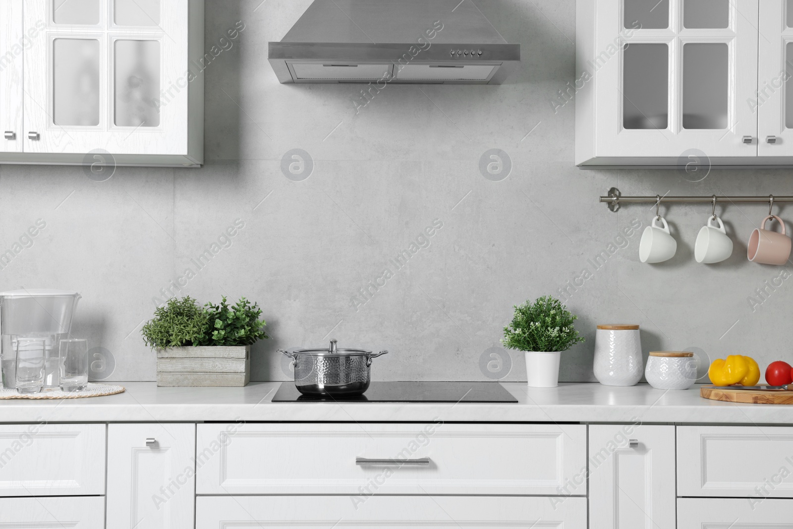 Photo of Potted artificial plants on white countertop in kitchen