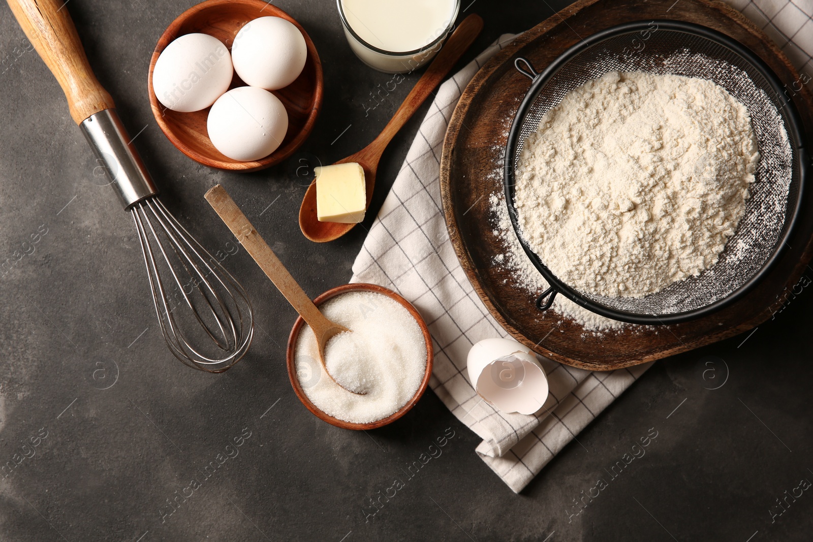 Photo of Different ingredients for dough on grey textured table, flat lay