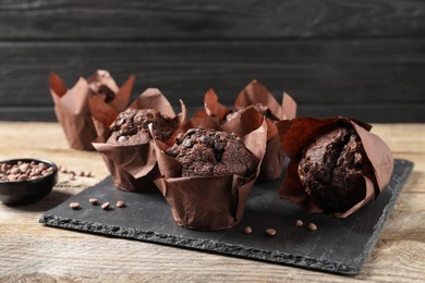 Photo of Delicious chocolate muffins on wooden table, closeup