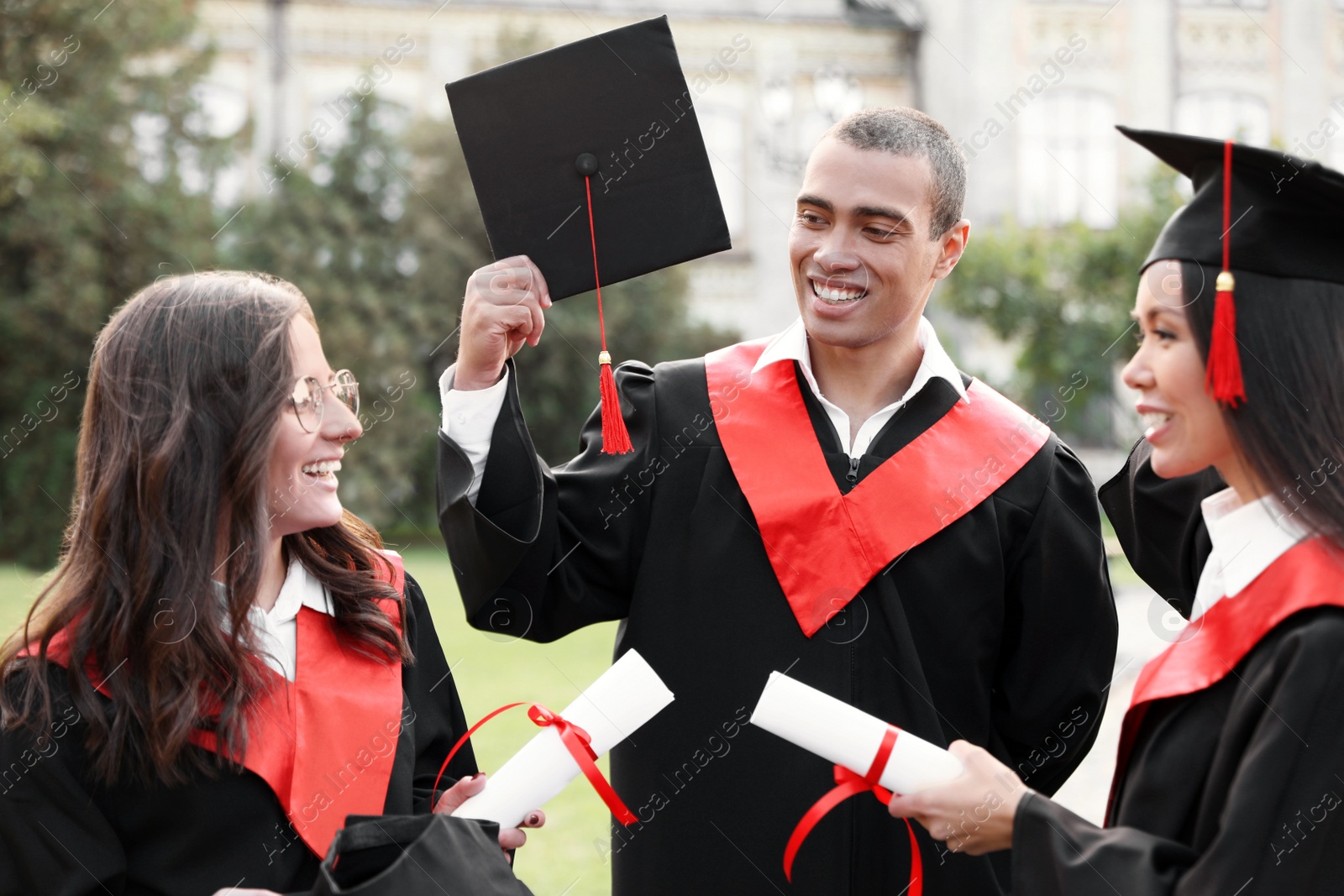 Photo of Group of happy students outdoors. Graduation ceremony