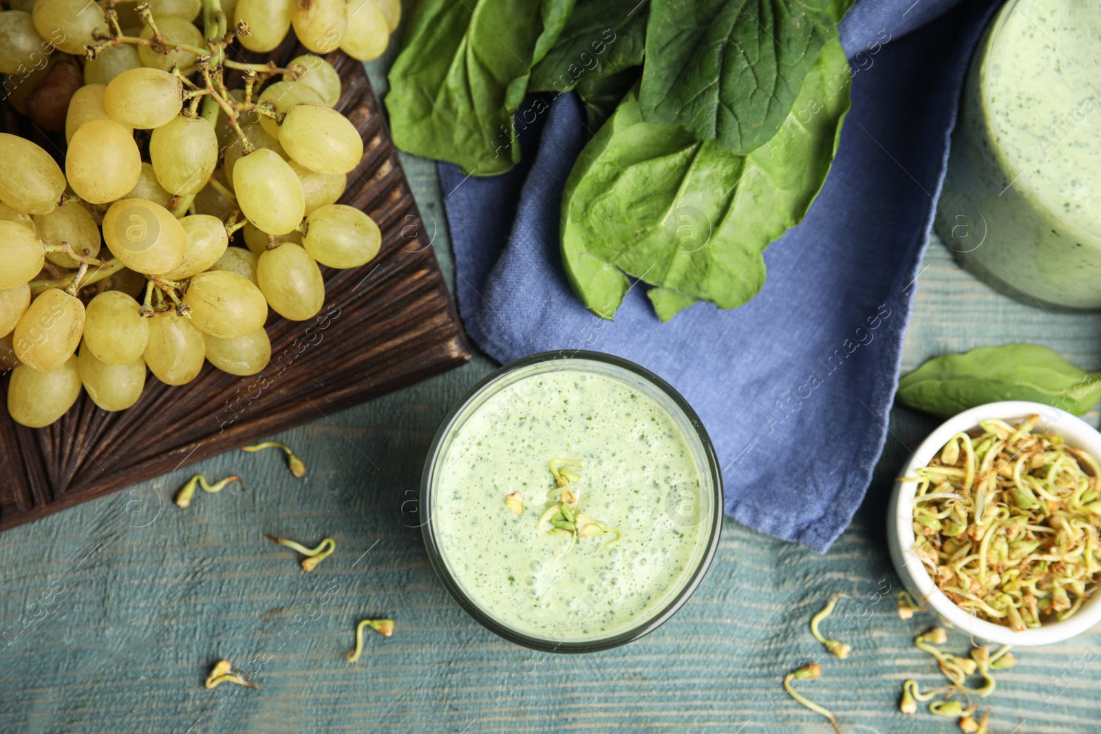 Photo of Flat lay composition with green buckwheat smoothie on light blue wooden table